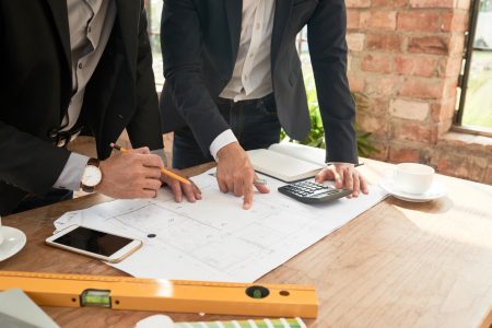 Cropped image of architects or engineers discussing project at meeting